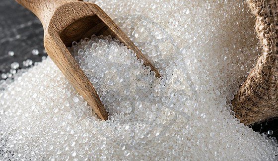 Refined white sugar — granulated crystals with a wooden scoop